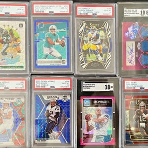 Puede incluir: Una colección de ocho tarjetas coleccionables de fútbol en estuches protectores. Las tarjetas presentan a varios jugadores, incluidos Joe Namath, Tua Tagovailoa, Aaron Donald, Justin Herbert, Tom Brady y Dak Prescott. Las tarjetas están en varias condiciones.