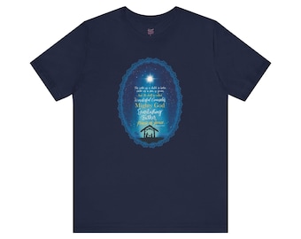 May include: Navy blue t-shirt featuring a blue oval design with a star and text. The text includes the words "Wonderful Counselor, Mighty God, Everlasting Father, Prince of Peace." A silhouette of a manger is at the bottom of the oval.