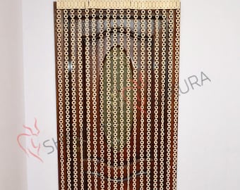 May include: A wooden bead curtain with a light brown color hangs in a doorway. The beads are round and connected in a chain-like pattern. The curtain is made of many strands of beads, creating a dense and decorative barrier.