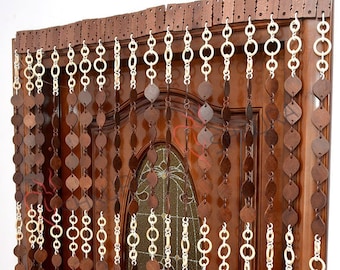 May include: A brown wooden beaded curtain with white wooden rings. The curtain is hanging on a wooden door.