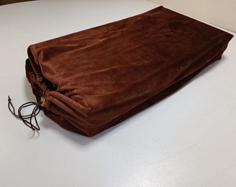 May include: A brown velvet drawstring bag with a gold drawstring closure.