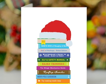 May include: A festive Christmas card design. A stack of books with titles like "Beard Trimming" and "North Pole Guidebook" is topped with a red Santa hat. The card is on a white background.