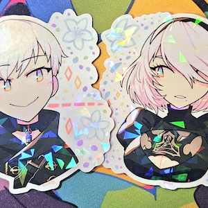 May include: Two holographic stickers featuring anime-style characters. One has white hair and a smiling expression, the other has pink hair and a serious expression. Both are wearing dark outfits with geometric accents, set against a floral background.