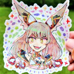 May include: A holographic sticker featuring a detailed anime-style character with large, pointed ears and a mischievous grin. The character is adorned with ornate, geometric designs and vibrant colors, set against a backdrop of colorful shapes and stars.