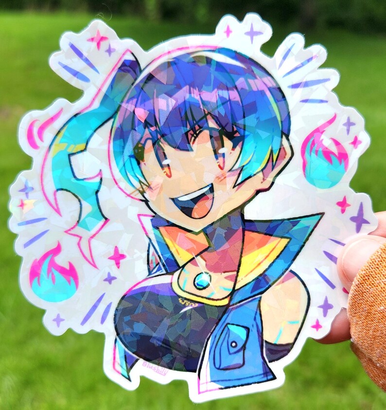 May include: A holographic sticker featuring a smiling anime-style character with blue and purple hair. The character wears a blue and yellow outfit with a gem. The sticker has a starburst design with pink and blue flames and stars.