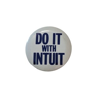 May include: A white button with the text "DO IT WITH INTUIT" in dark blue. The button is round and has a glossy finish. The text is centered and easy to read, making it a clear and concise statement.