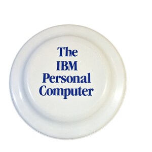 May include: White plastic frisbee with blue text that reads "The IBM Personal Computer"
