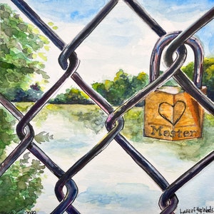 以下が含まれることがあります： チェーンリンクフェンス越しに見える、ハートのデザインと「マスター」という刻印がされた金色の南京錠。南京錠はフェンスにかけられており、背景には湖と木々が見える。