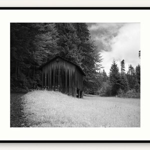 Black and white photograph of a mountain cabin on Mount Pilatus in the Swiss Alps, shown framed in black with a white mat