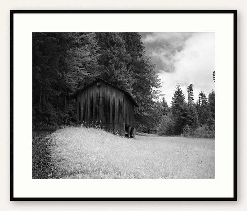Black and white photograph of a mountain cabin on Mount Pilatus in the Swiss Alps, shown framed in black with a white mat