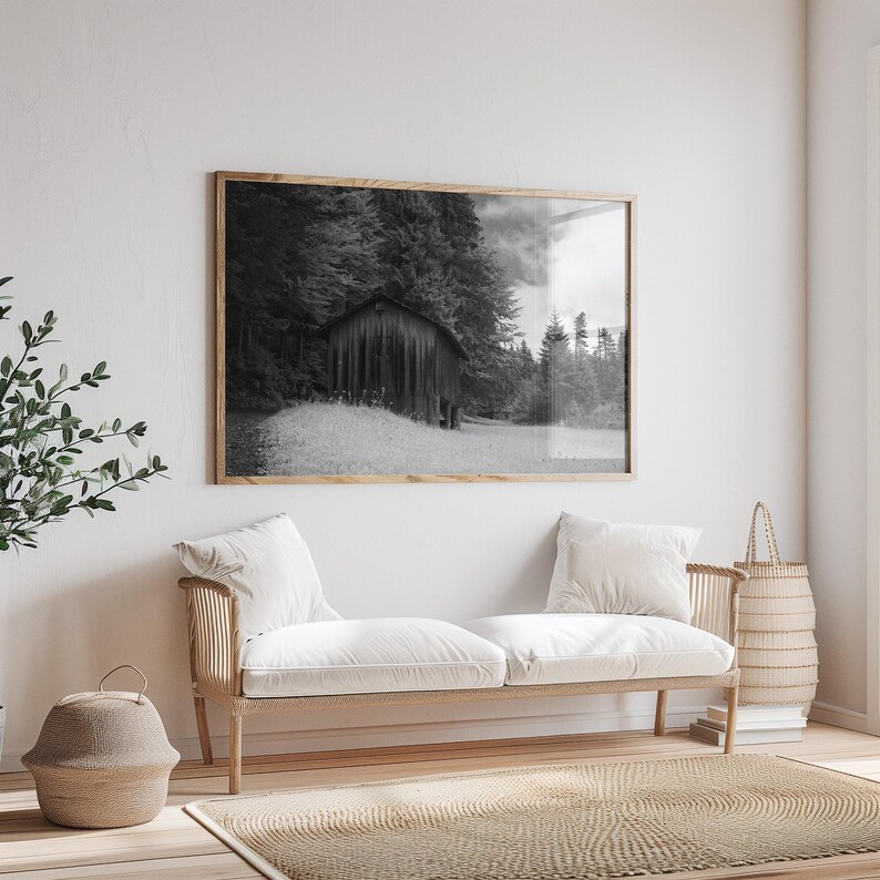 Black and white photograph of a mountain cabin on Mount Pilatus in the Swiss Alps, shown as a framed print on a gallery wall