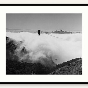 Black and white photograph of the Golden Gate Bridge sinking into fog, shot on 4x5 film, shown framed in black with a white mat