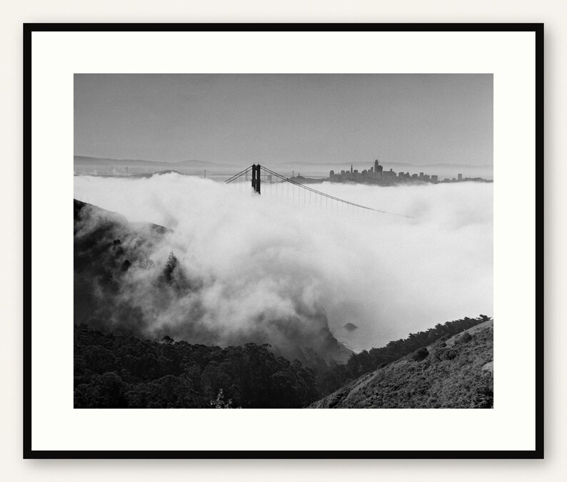 Black and white photograph of the Golden Gate Bridge sinking into fog, shot on 4x5 film, shown framed in black with a white mat