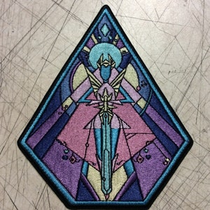 May include: A blue and purple embroidered patch with a geometric design featuring a figure holding a sword. The figure is surrounded by a stained glass-like pattern.