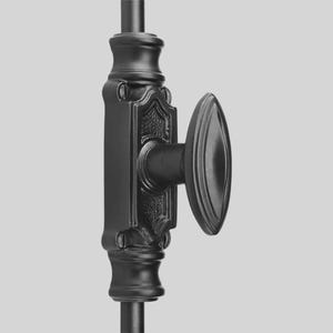 May include: A matte black window sash lock featuring an oval-shaped knob and a rectangular base plate with decorative textured detailing. The hardware is mounted on a vertical rod, showcasing a solid construction with visible screw heads.