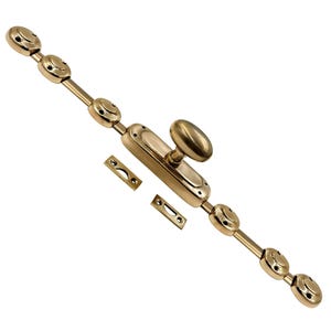 Op de afbeelding: Een messingkleurige kastbout met een ovale handgreep en decoratieve cirkelvormige accenten. Inclusief twee rechthoekige sluitplaten. De bout is ontworpen voor het beveiligen van deuren of kasten.