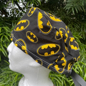 Black and yellow bat Scrub Cap with Buttons. A few evil faces that haunt this vibrant hat