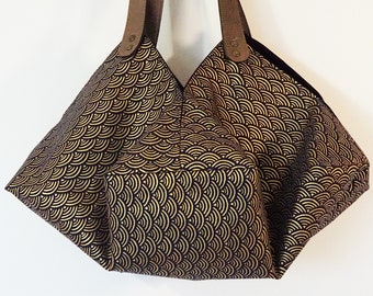 May include: A black tote bag with gold scale pattern and brown leather straps.