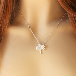 May include: A silver necklace featuring a tree pendant. The tree is crafted from fine branches and leaves.