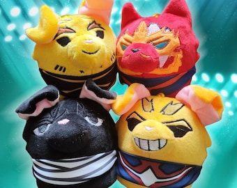 May include: Four plush toys in the shape of animal heads. The toys are yellow, red, black, and yellow with black and red accents. The toys are all smiling and have large eyes.