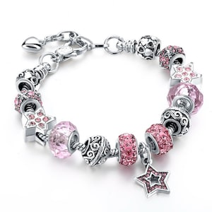 May include: A silver charm bracelet featuring pink crystal beads and star charms. The bracelet has a heart-shaped clasp.