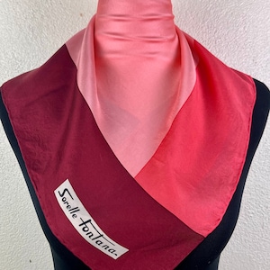 May include: A pink, red, and burgundy silk scarf with the text "Sorelle Fontana" printed on the burgundy section.