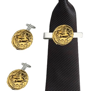 Puede incluir: Una corbata negra con un pasador de corbata dorado con forma de moneda de caballo y dos gemelos a juego. El pasador de corbata y los gemelos presentan un relieve detallado de un caballo.