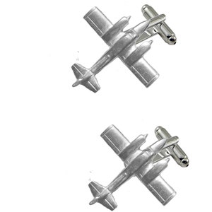 Pode incluir: Um par de botões de punho de prata com um design de avião detalhado. Os botões de punho são feitos de metal e têm um acabamento polido.