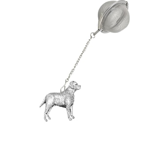 May include: A silver tea infuser with a Labrador Retriever design. The infuser has a round mesh ball with a chain attached to a dog-shaped handle.