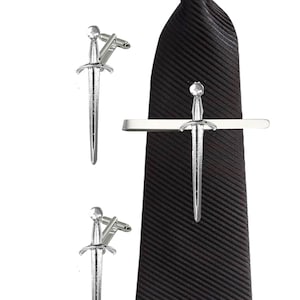May include: A set of silver sword cufflinks and a matching tie bar. The tie bar is attached to a black tie.