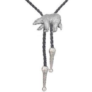 May include: A bolo tie featuring a pewter polar bear charm on a black braided cord with silver tips.
