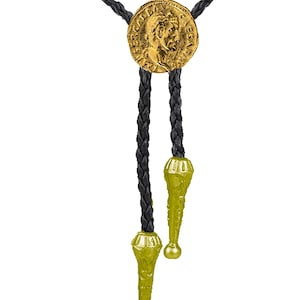 Puede incluir: Un corbatín bolo trenzado negro con una moneda de oro que presenta el perfil de un emperador romano. La corbata tiene dos borlas doradas.