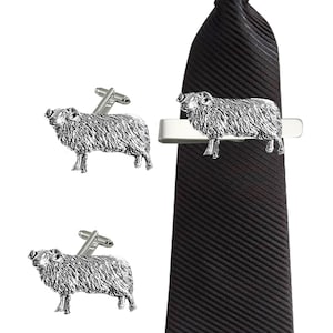 Pode incluir: Um conjunto de botões de punho de prata em forma de ovelha e um prendedor de gravata. As ovelhas são detalhadas e realistas, com uma textura de lã fofa. O prendedor de gravata é de prata e tem um design simples.