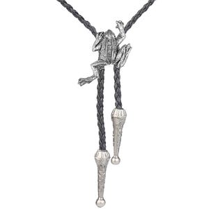 May include: A silver frog bolo tie with a black braided leather cord. The frog is perched on the cord and has a detailed design. The bolo tie has silver tips.