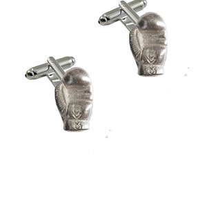 May include: A pair of silver cufflinks featuring a boxing glove design.