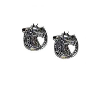 May include: A pair of silver cufflinks featuring a horse's head inside a horseshoe.