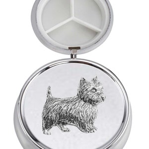 Könnte beinhalten: Eine silberne Pillendose mit einem weißen Westie-Hundedesign auf dem Deckel. Die Dose hat drei Fächer im Inneren.
