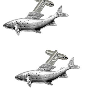 Puede incluir: Un par de gemelos de plata con un diseño realista y detallado de una trucha. Los gemelos están hechos de metal de alta calidad y tienen un acabado pulido.