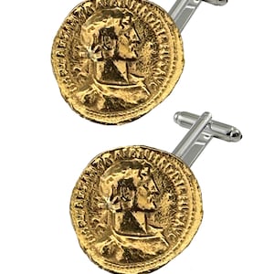 Puede incluir: Un par de gemelos dorados con diseño de moneda romana. Cada gemelo tiene una imagen detallada del perfil de un emperador romano en un lado y letras romanas en el otro.