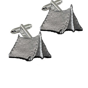 May include: A pair of silver cufflinks featuring a detailed design of a tent. The cufflinks are made of metal and have a polished finish.