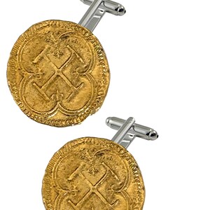 Puede incluir: Un par de gemelos de oro con un diseño de cruz estilizado. Los gemelos están hechos de metal y tienen un acabado plateado.
