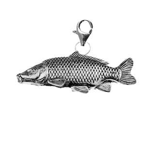 May include: A silver charm in the shape of a fish. The fish has a detailed design with scales and fins.