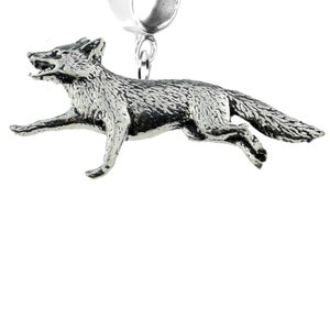 May include: A silver charm in the shape of a fox running. The charm is attached to a silver ring.