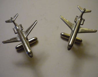 May include: A pair of silver airplane cufflinks. Each cufflink features a detailed model of a silver aeroplane.