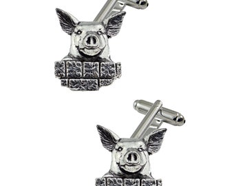 May include: A pair of silver cufflinks featuring a pig's head peeking out of a brick wall.