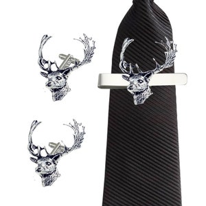 May include: A set of silver stag cufflinks and a matching tie bar. The stag is depicted in a realistic style with detailed antlers and a textured finish.