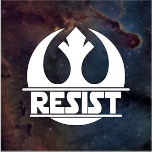 May include: White graphic of a stylized emblem with the word "RESIST" in bold capital letters. The emblem is set against a backdrop of a nebula with shades of blue, purple, and brown.