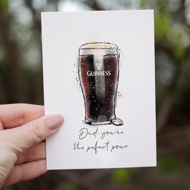 Puede incluir: Una tarjeta blanca con una ilustraci&oacute;n dibujada a mano de un vaso de cerveza Guinness. El texto "Dad, you're the perfect pour" est&aacute; escrito debajo de la ilustraci&oacute;n.