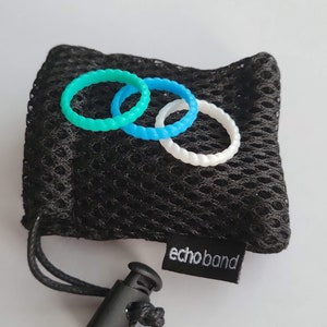 May include: A black mesh bag with a drawstring closure, holding three colorful silicone rings. The rings are teal, light blue, and white. The bag has a small tag that reads "echoband".