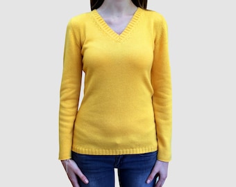 May include: A yellow long-sleeved sweater with a v-neck.